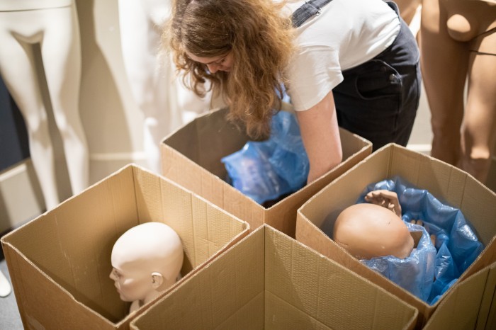 Collection Manager Elaine Uttley packing mannequin torsos into boxes in the Fashion Museum galleries