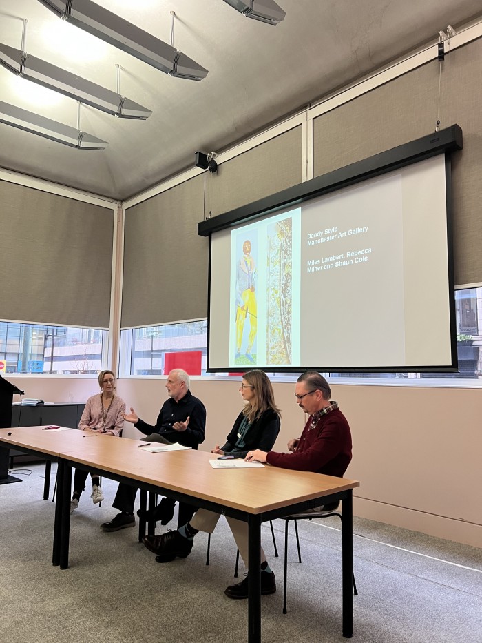 Curators Rosie Gnatiuk, Miles Lambert, Rebecca Milner, and Shaun Cole (left to right) delivering a talk on the 'Dandy Style' exhibition. 