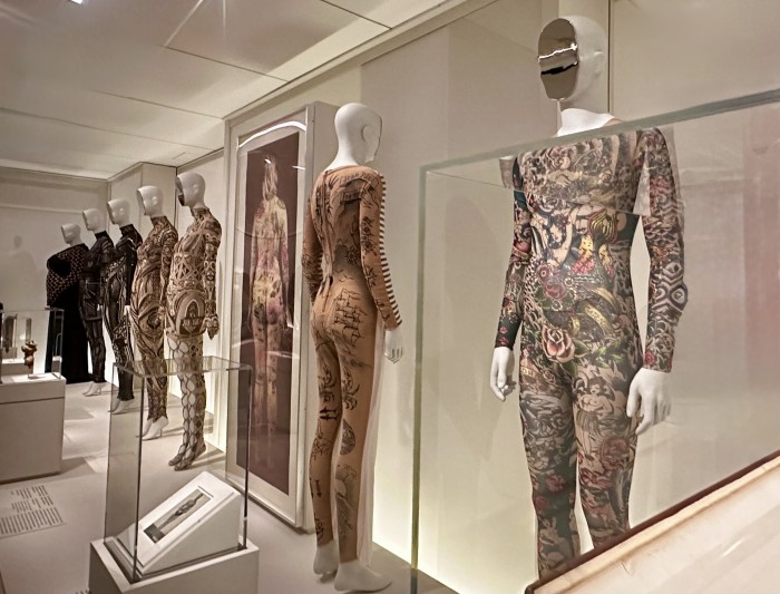 Inscribed Body: DSquared  (Italian) Jumpsuit 2016. Jean Paul Gaultier (French) Jumpsuit, 1993. Jane Hammond Tabula Rosa 2001.bSomarta, Tamae Hirokawa (Japan) Tribal SOMA Bijou Bodysuit, 2014, Alexander McQueen (British) Bodysuit, 2003, Yiqing Yin ( China) , Maori ensemble, 2015. Marine Serre (French) Regenerated Jersey Draped Dress, 2024. © Photo Jane Francis