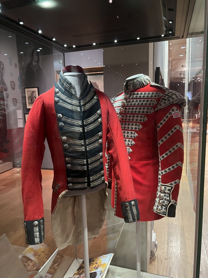 Military jackets on display alongside the images of famous musicians in military-inspired styles.